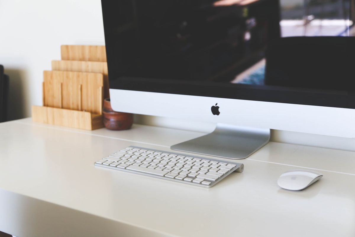 Ancien iMac avec clavier et souris sur un bureau ; illustration générique, pas le nouvel iMac M6