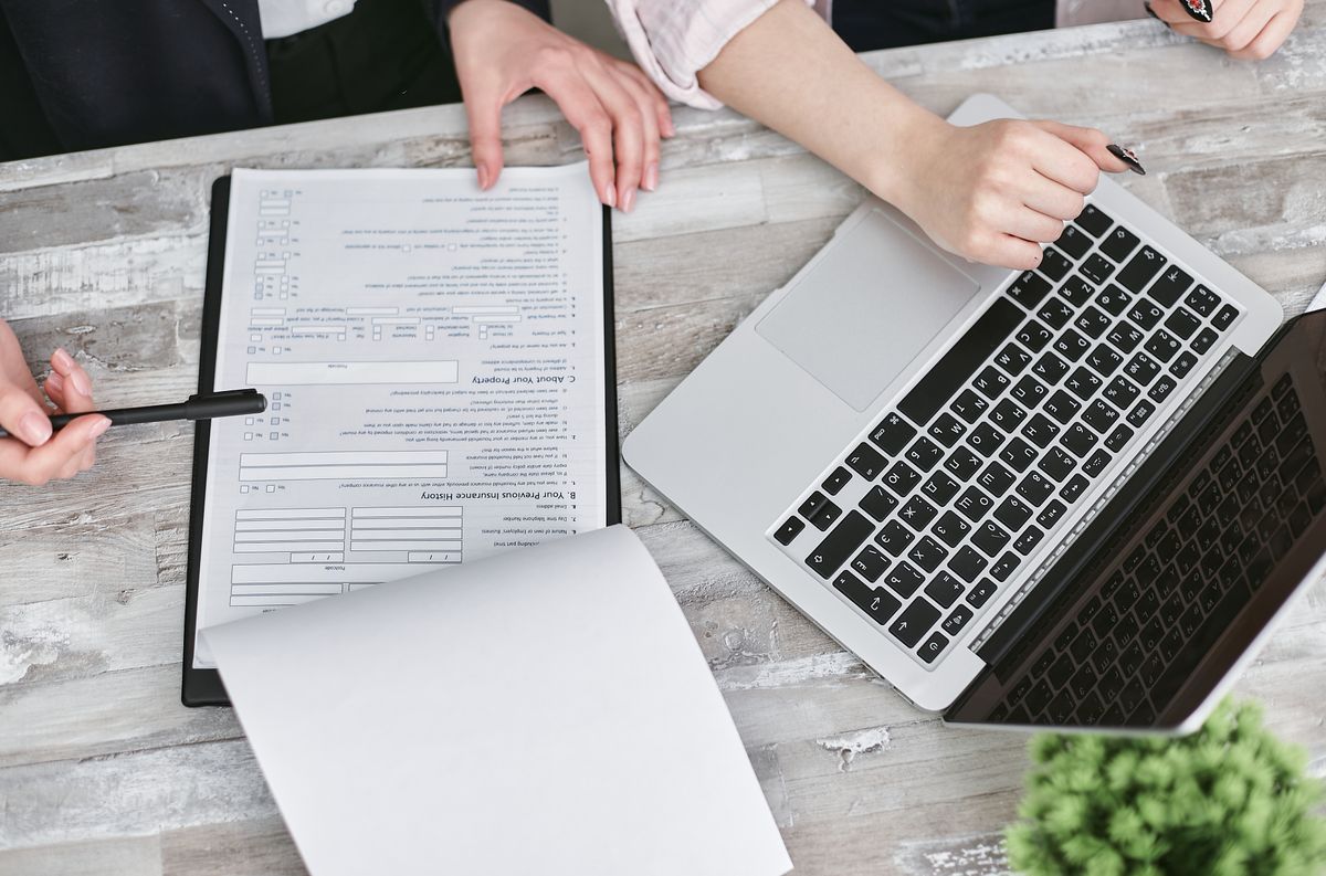 Documents examinés à côté d’un ordinateur portable sur une table de travail