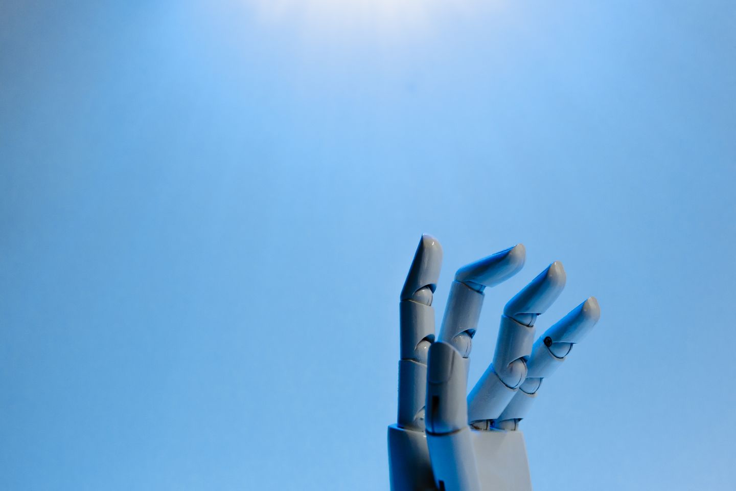 Une main robotique articulée sur un fond bleu, illustration de l’action assistée